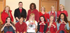 Photo of County Employees wearing red and making a heart symbol.
