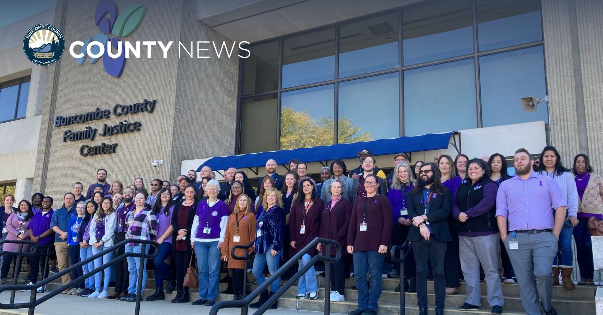 a group of people stands on the steps at the Family Justice Center