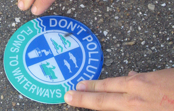 Storm drain marker: Don't Pollute; Flows to Waterways