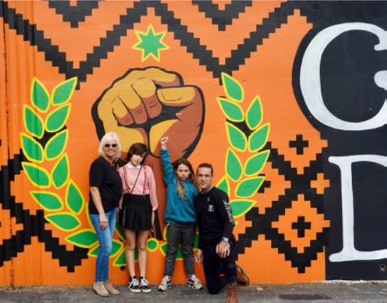 people stand in front of an orange wall