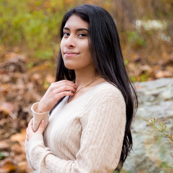 a woman with long hair stands on a green background