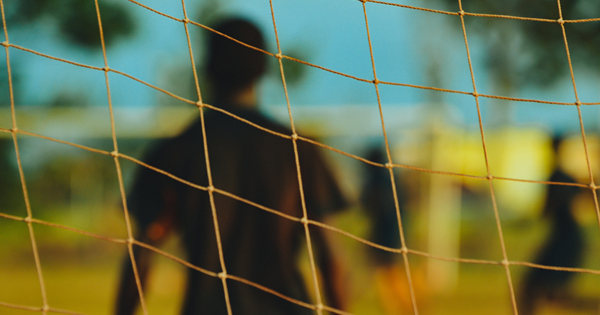 Goalie behind soccer goal