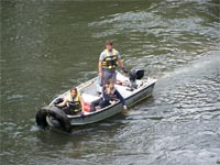 Photo of people in a boat helping with the river cleanup.