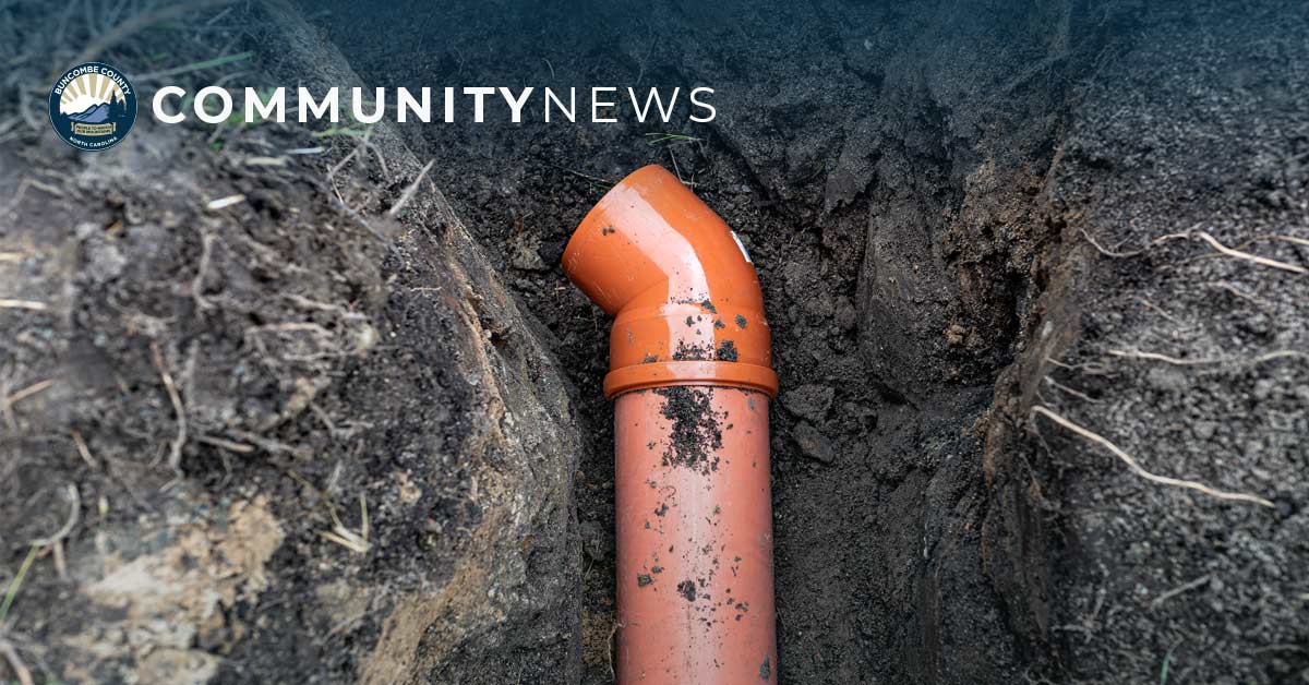 orange septic pipe lays in a ditch