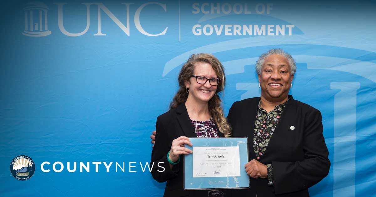 Commissioner Wells holds a certificate with another elected leader