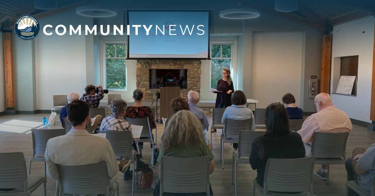 a man raises his hand at a community meeting